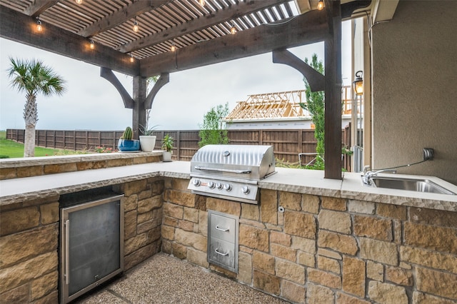 view of patio / terrace featuring an outdoor kitchen, a grill, a sink, a pergola, and a fenced backyard