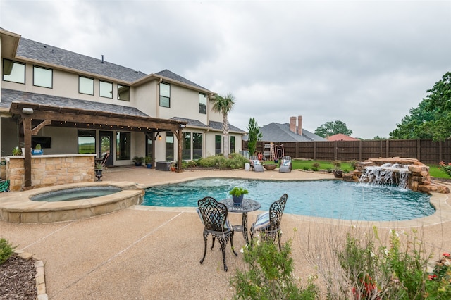 view of swimming pool featuring a pool with connected hot tub, a patio area, and a fenced backyard