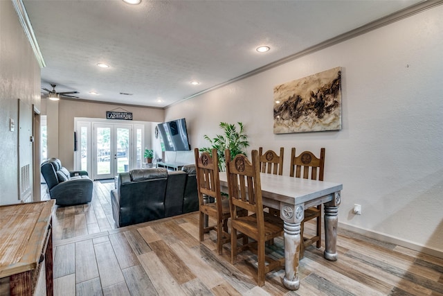 dining space featuring ornamental molding, french doors, and light hardwood / wood-style floors