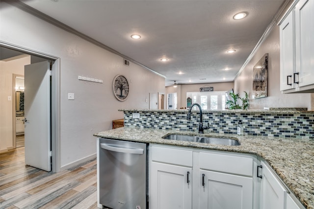 kitchen with light wood-type flooring, light stone countertops, sink, and stainless steel dishwasher