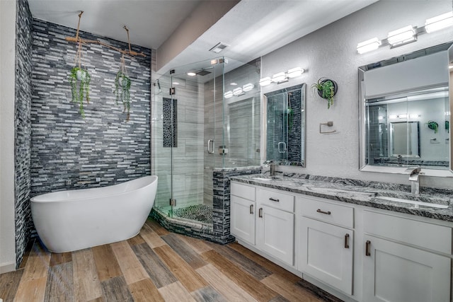 bathroom featuring hardwood / wood-style floors, separate shower and tub, tile walls, and vanity