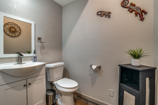 bathroom featuring hardwood / wood-style flooring, toilet, and vanity