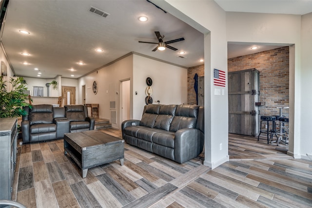 living room with crown molding, brick wall, ceiling fan, and hardwood / wood-style floors