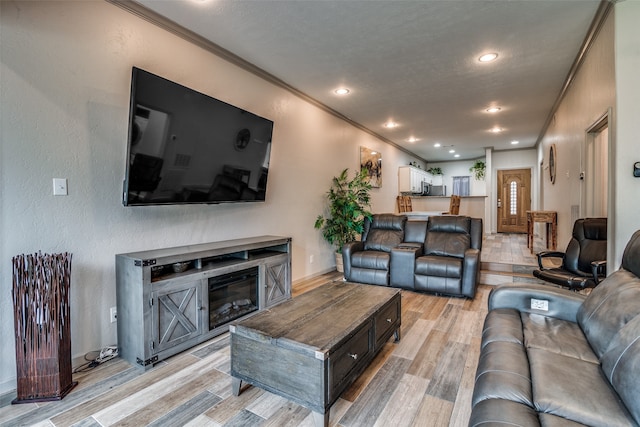 living room with light wood-type flooring and ornamental molding