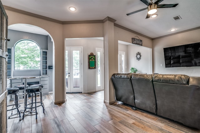 living room with crown molding, ceiling fan, and hardwood / wood-style floors