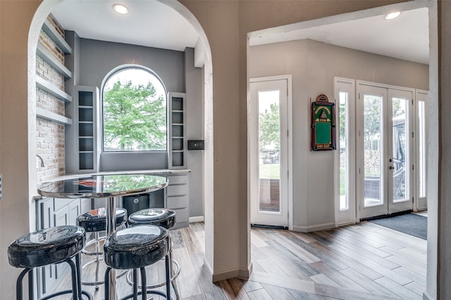 interior space with light hardwood / wood-style floors, a healthy amount of sunlight, and french doors