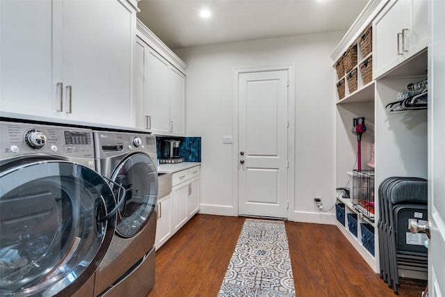 clothes washing area featuring dark hardwood / wood-style flooring, cabinets, and washer and dryer