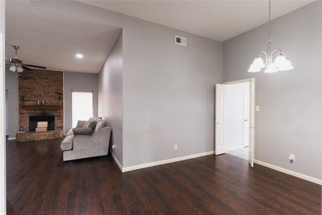 living room featuring ceiling fan with notable chandelier, dark hardwood / wood-style flooring, a fireplace, and lofted ceiling