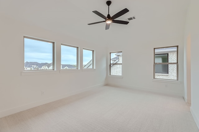 spare room featuring light carpet and ceiling fan