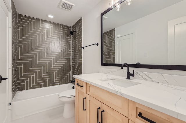 full bathroom featuring tiled shower / bath, vanity, and toilet