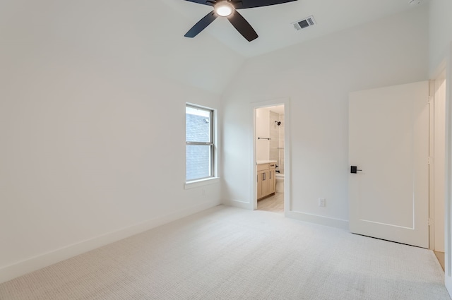 unfurnished bedroom featuring lofted ceiling, ensuite bath, ceiling fan, and light colored carpet