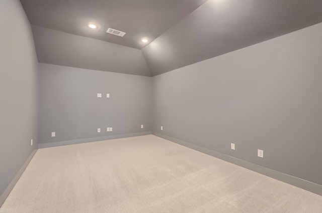 carpeted empty room with lofted ceiling