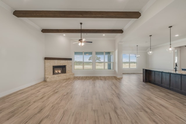 unfurnished living room with ceiling fan, a fireplace, ornamental molding, and light hardwood / wood-style flooring