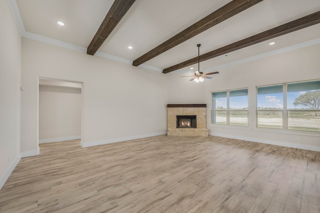 unfurnished living room with a stone fireplace, light wood-type flooring, beam ceiling, ceiling fan, and ornamental molding