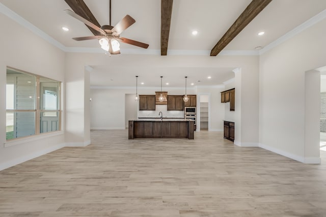 kitchen with ceiling fan, pendant lighting, beamed ceiling, stainless steel microwave, and light hardwood / wood-style floors