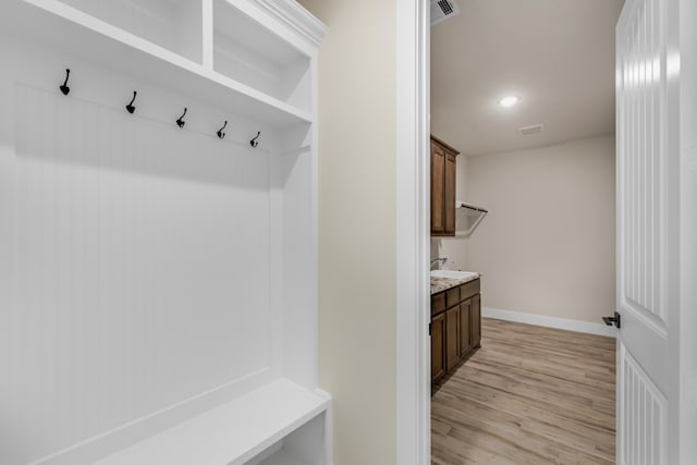 mudroom with light hardwood / wood-style floors and sink