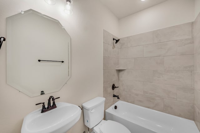 full bathroom with tiled shower / bath, sink, and toilet