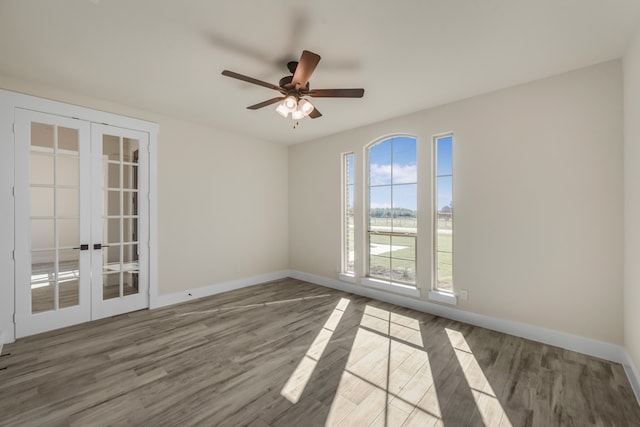 spare room with ceiling fan, hardwood / wood-style flooring, and french doors