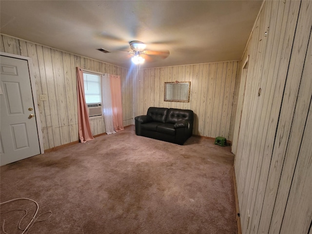 sitting room featuring wooden walls, carpet flooring, cooling unit, and ceiling fan