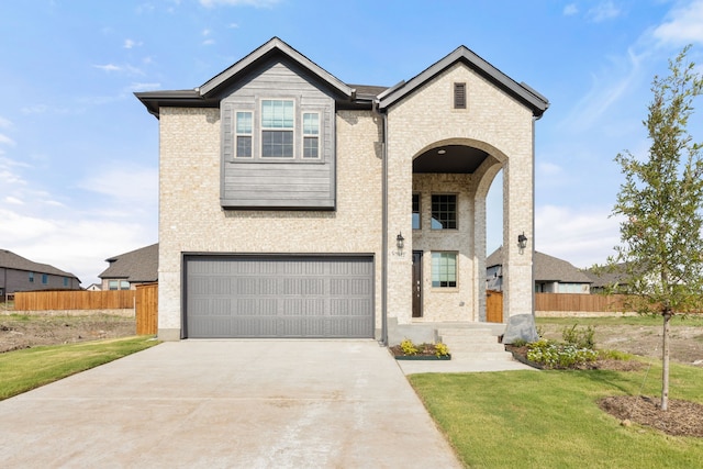 view of front of house featuring driveway, brick siding, an attached garage, and fence