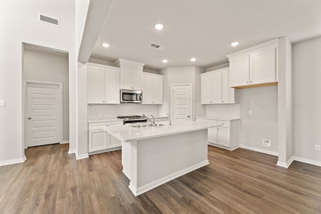 kitchen with stainless steel appliances, dark wood finished floors, visible vents, and a sink