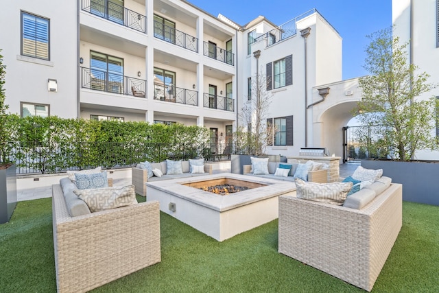 view of patio with a balcony and an outdoor living space with a fire pit