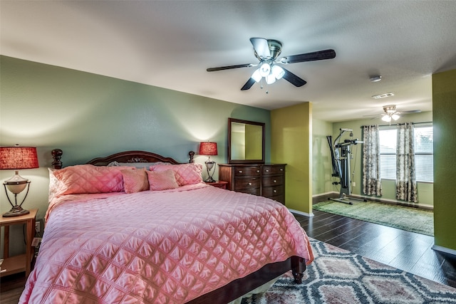 bedroom with dark wood-type flooring, ceiling fan, and a textured ceiling