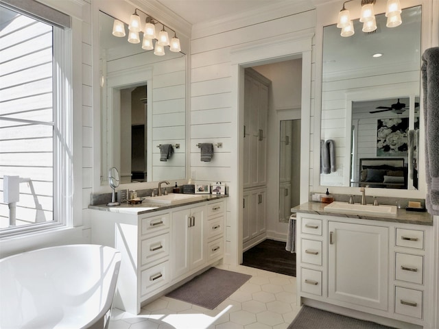 bathroom with ornamental molding, dual bowl vanity, a bathing tub, and tile flooring