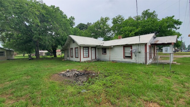 rear view of property with a lawn