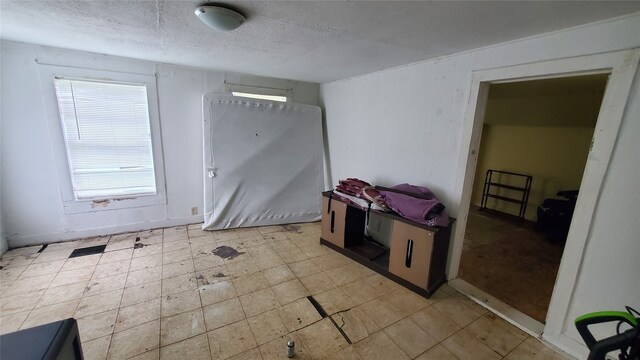 interior space featuring light tile flooring and a textured ceiling