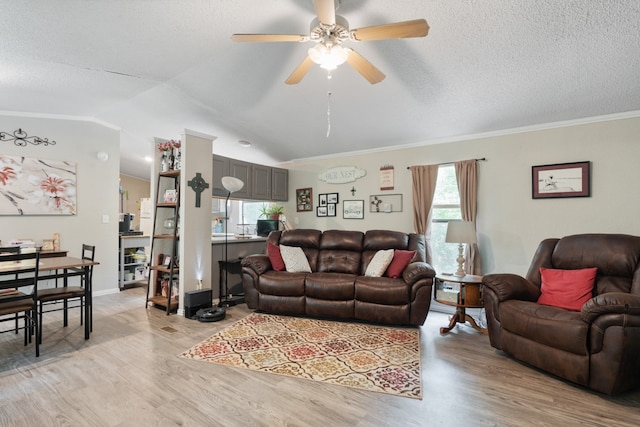 living room with crown molding, light hardwood / wood-style floors, ceiling fan, a textured ceiling, and lofted ceiling