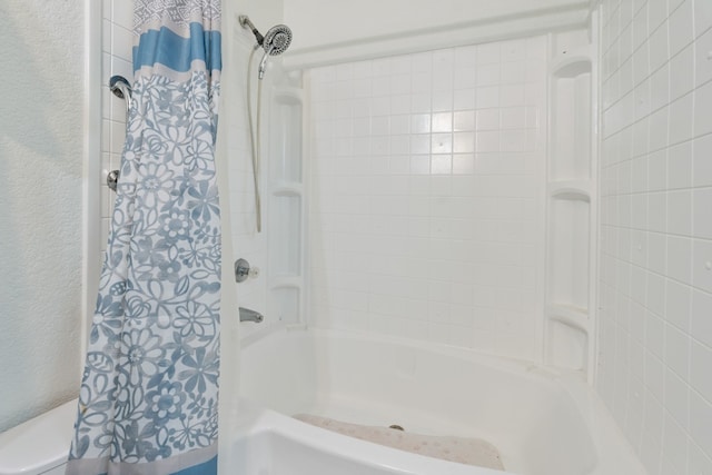 bathroom with shower / tub combo and toilet