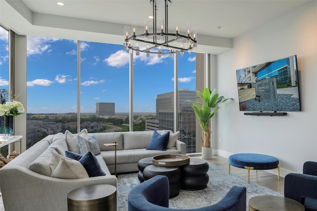 living room featuring a notable chandelier, plenty of natural light, and wood-type flooring