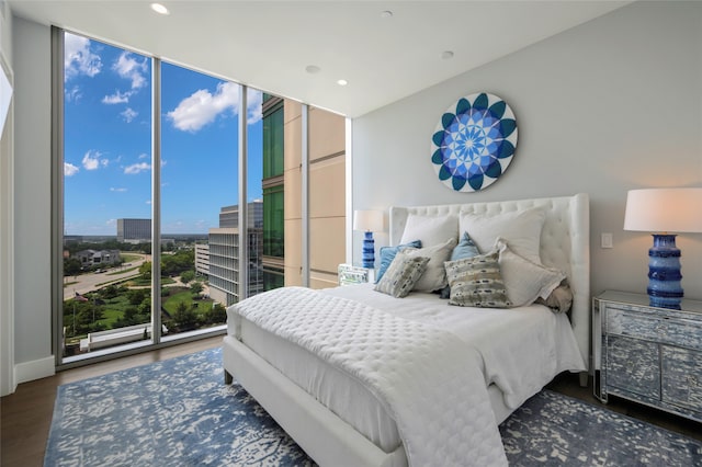 bedroom featuring a wall of windows and dark hardwood / wood-style flooring