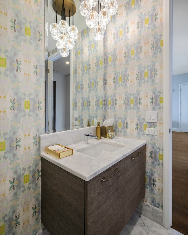 bathroom with a chandelier, vanity, and wood-type flooring