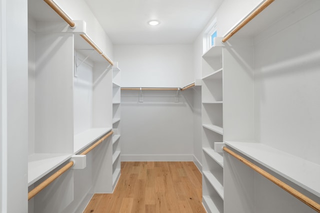 walk in closet with light hardwood / wood-style flooring