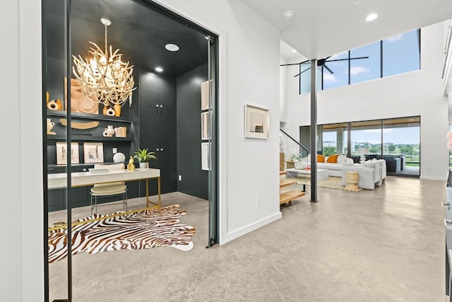 hallway with concrete flooring and an inviting chandelier