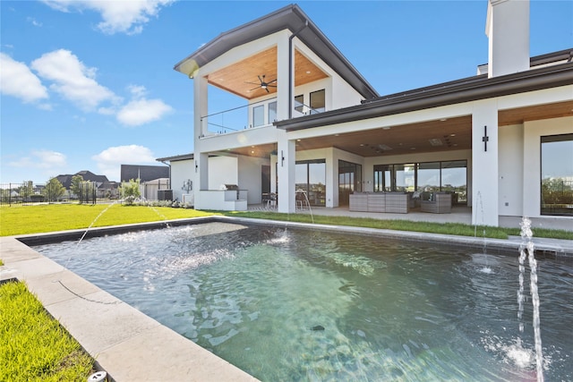 view of swimming pool featuring ceiling fan, a lawn, a patio, and pool water feature