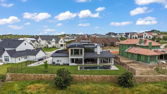 back of property featuring a lawn and a fenced in pool