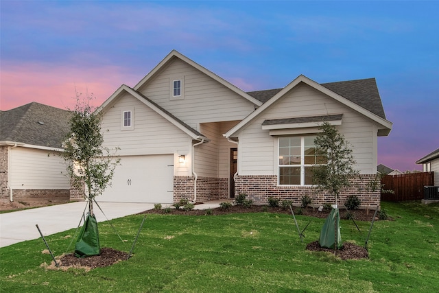 view of front of home featuring central AC, a yard, and a garage