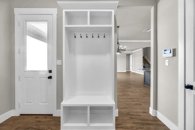 mudroom featuring dark wood-type flooring and an inviting chandelier