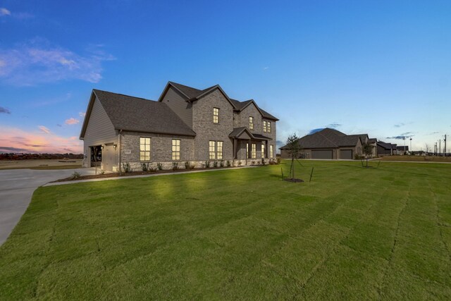 view of front of home with a garage and a yard