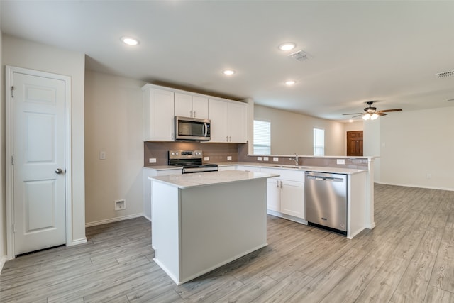 kitchen featuring white cabinetry, a center island, stainless steel appliances, and ceiling fan