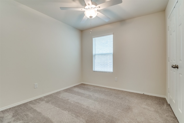 carpeted spare room featuring ceiling fan