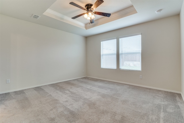 empty room featuring ceiling fan, carpet flooring, and a tray ceiling