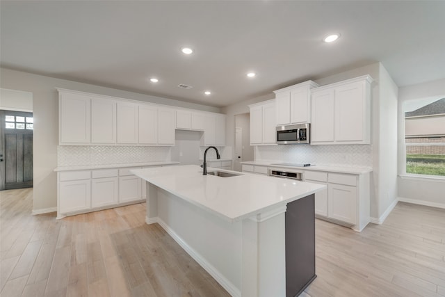 kitchen featuring white cabinetry, light hardwood / wood-style flooring, sink, and a wealth of natural light