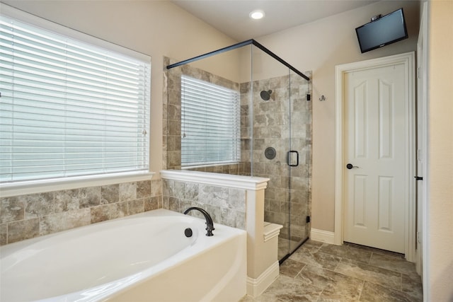 bathroom with shower with separate bathtub and tile floors