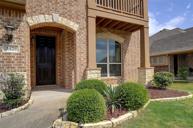 view of exterior entry featuring a balcony