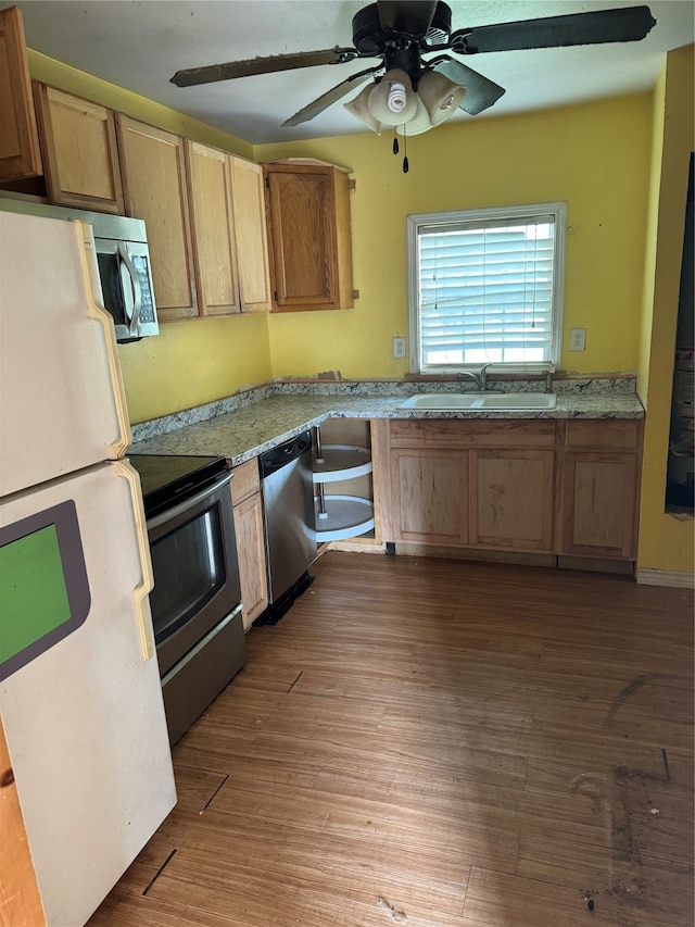 kitchen with hardwood / wood-style flooring, stainless steel appliances, ceiling fan, and sink