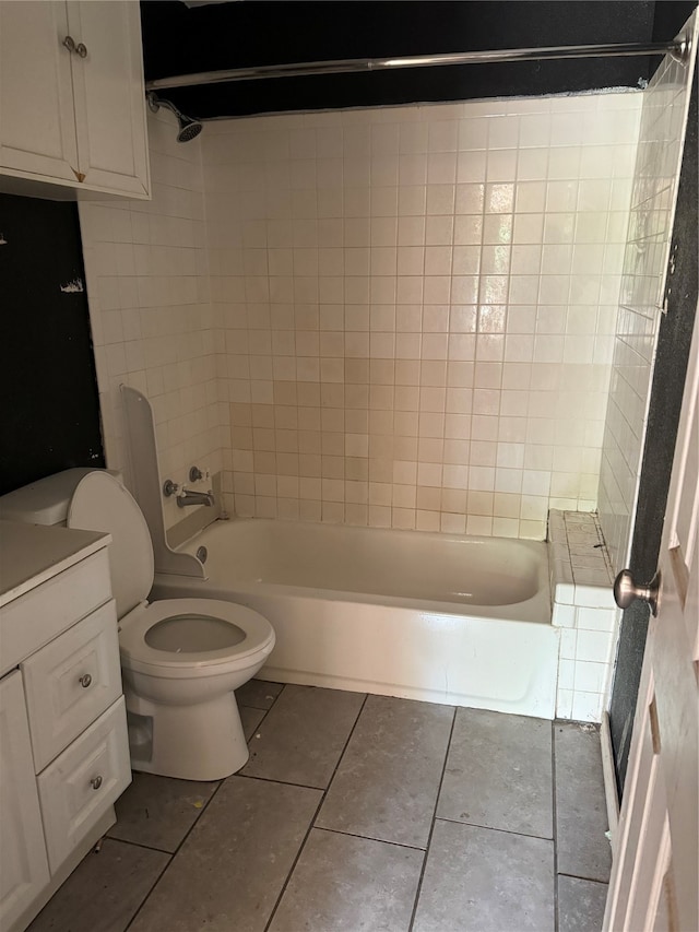 full bathroom with tiled shower / bath, toilet, tile flooring, and vanity